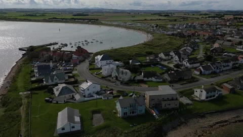 Aerial View Beadnell Bay During the Summer with Beach Goers, Boats and a Surfer 스톡 동영상 281089356
