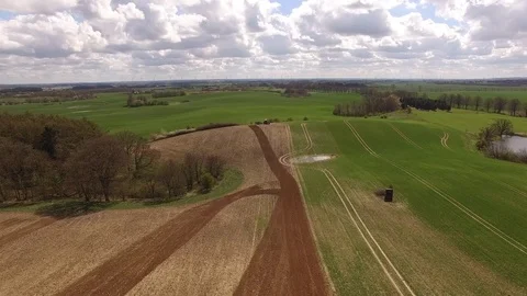 Aerial view of beautiful agricultural fields with a tractor cultivating a field Stock Footage 74987797