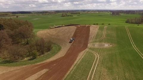 Aerial view of beautiful agricultural fields with a tractor cultivating a field Stock Footage 74988545