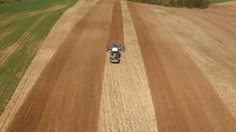 Aerial view of beautiful agricultural fields with a tractor cultivating a field Stock Footage 74988744