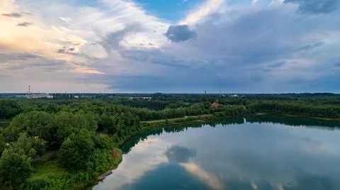 Aerial view of a beautiful and dramatic sunset over a forest lake reflected in Stock Photos