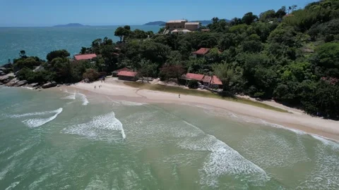 Aerial view of a beautiful beach with clear sand, forest, rocks and quiet Stock Footage 229853159