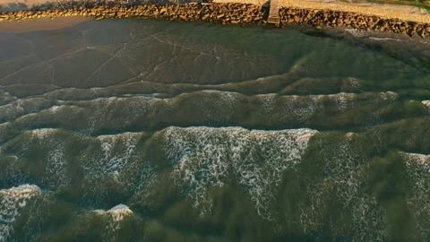 Aerial view of beautiful beach with view of ocean waves and water crashing on Stock Footage 153296155