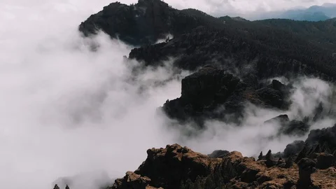 Aerial view - beautiful clouds curl in the gorges of the mountains, view from a Stock Footage 113229455