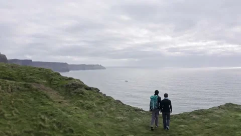 Aerial view of beautiful irish cliffs, young couple walk, watch the landscape 動画素材 208312490