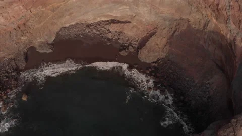Aerial view. Beautiful isolated beach beside a cliff. Black sand. Green water. Stock Footage 151282003