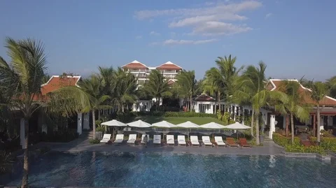 Aerial View of Beautiful Pool Area among Palm Trees in a luxury resort Stock Footage 98010513