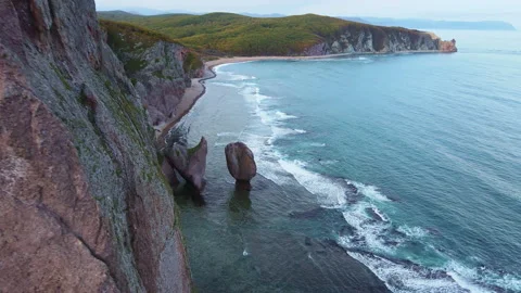 Aerial view of beautiful sea stack and dark cliffs in sunset. Calm seascape Stock Footage 222933221