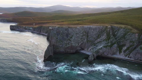 Aerial view of beautiful sea stack and dark cliffs in sunset. Calm seascape Stock Footage 222934439