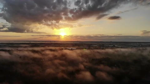 Aerial view of beautiful sunrise reveal over water Stock Footage