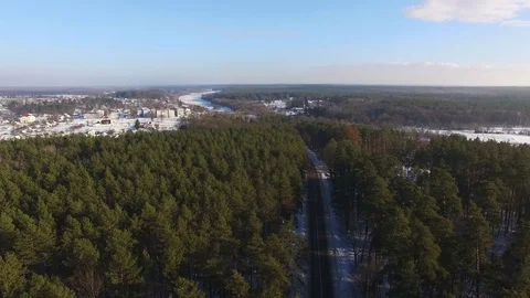 Aerial View. Beautiful winter forest in sunny day. Road between the trees. Stock Footage 71444602