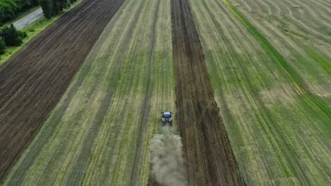 Aerial view behind the tractor plows the land in the village. The process of  Stock Footage 137263649