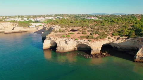 Aerial view of Benagil Caves with kayaks swimming in blue oceanic waters in 4K. Stock Footage 163341353