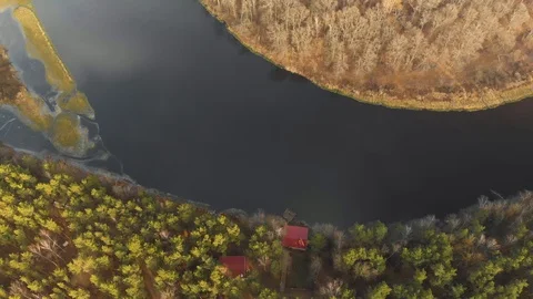 Aerial view of a bend in the river with the roofs of private households in the Vídeos de archivo 129212696