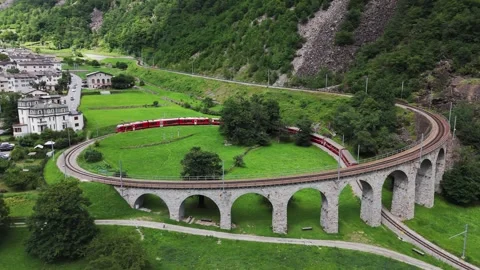 Aerial view of a Bernina Express train crossing the Brusio spiral viaduct Stock Footage 288678606