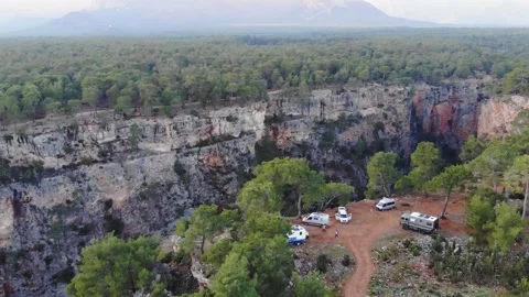 Aerial View Of Big Canyon Surrounded By Forest With A Group Of Cars On The Edge Stock Footage 195096562