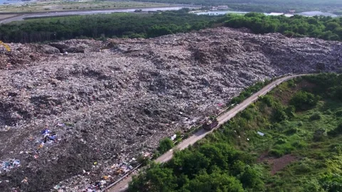 Aerial view of big garbage dump surrounded by greenery, environmental pollution Stock Footage 295953153