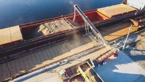 Aerial view of big grain elevators on the sea. Loading of grain on ship. Port Stock Photos