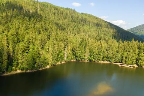 Aerial view of big lake with clear blue water between high mountain hills cov Stock Photos