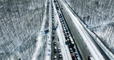 Aerial view of big traffic jam on the high way during winter snow storm Stock Footage 194473808