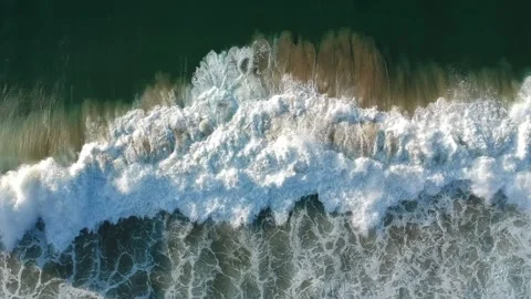 Aerial view from a big waves crashing in a beach. Drone view Video stock 134836628