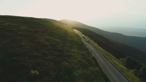 Aerial view of biker going down a mountain passage road at sunset Stock Footage 157631549