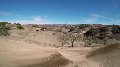 Aerial view of a biker on a jump while another rides below in desert race track Stock Footage 92107602