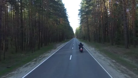 Aerial view of a biker riding a forest road, shot drone Stock Footage 107657041