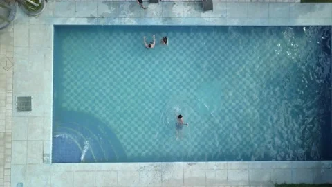 Aerial view of bird with drone of several friends in a pool swimming on a sunny Stock Footage 161964696
