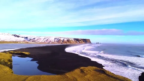 Aerial view of black sand beach with snowy mountains and ocean waves in Iceland. Stockbeeldmateriaal 342373363