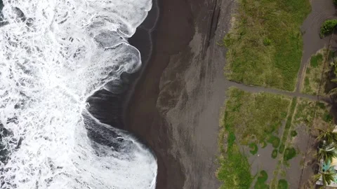 Aerial view of a black sand beach hit by big waves Stock Footage 344680912