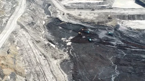 An aerial view of a blackened coal mine pit filled with coal, as well as th.. Stock Footage 328712816