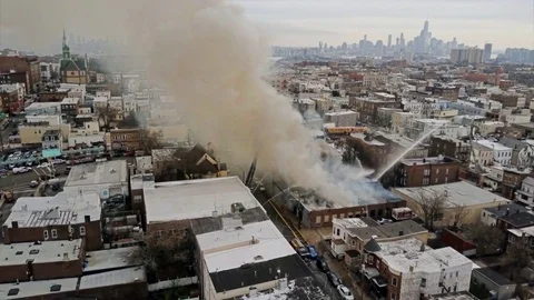 Aerial View blazing warehouse fire with water high pressure hose 4K Stock Footage 80605865
