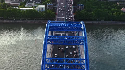 Aerial view of a blue bridge over a river bustling with cars in an urban setting Video stock 309093853