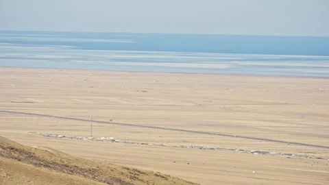 Aerial View of Blue Ocean with Floating Ice and Yellow Grassland with Small Vill 스톡 동영상 326416859