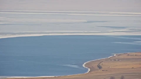 Aerial View of Blue Ocean with Floating Ice and Yellow Grassland with Small Hous Stock-Footage 326424200