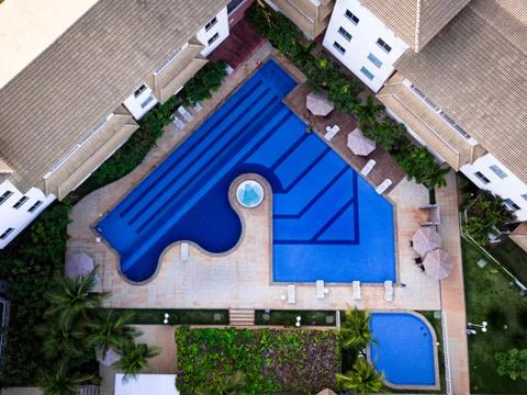 Aerial view of a blue pool with vacation apartments surround it.   Stock Photos