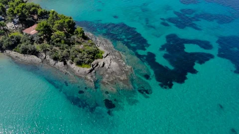 Aerial view of blue sea surface on rocky coast with light reflections. Stock Footage 107985384