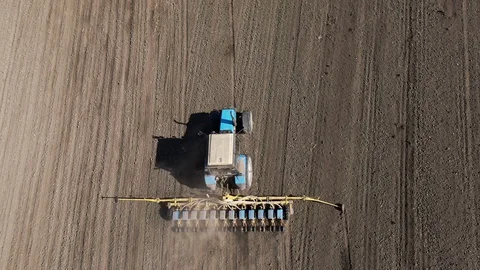 Aerial view blue tractor with a seeder goes across the field. Stock-Footage 128368622