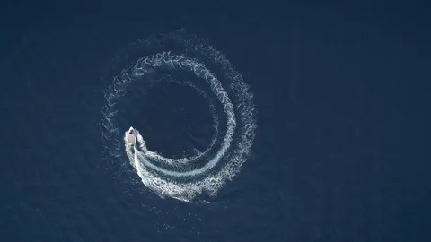 Aerial view of a boat driving in circles forming waves around in Greece. Stock Footage 94266097