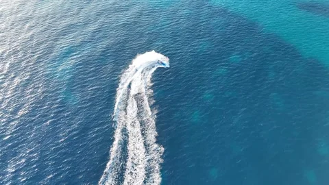 Aerial view of boat floating across the vibrant blue sea, creating dynamic Video stock 341126554
