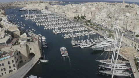Aerial view boat floating between moored sailboats harbour Birgu old town Malta Vídeo Stock 130889814