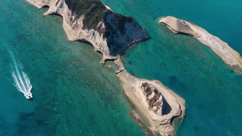 Aerial view of boat moving through turquoise sea near Cape Drastis dramatic Видео 345001451
