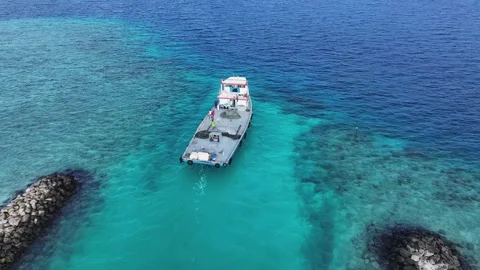 Aerial view of a boat navigating a channel between breakwaters, Maldives. Stock Footage 334323349