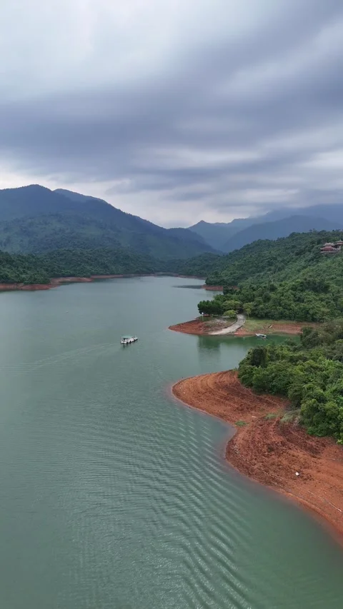 Aerial View of a Boat Navigating a Mountain Lake in Hue, Vietnam Stock-Footage 335845966