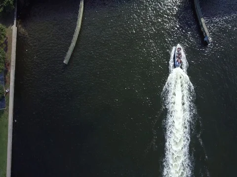 Aerial view of a boat passing under a bridge where cars drive by Stock Footage 78687493