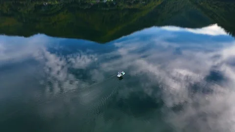 Aerial view of a boat sailing on a calm lake with clouds reflection 库存影片 341302012