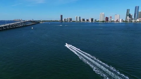 Aerial view of boat speeding through beautiful blue water with picturesque Stock Footage 256692048