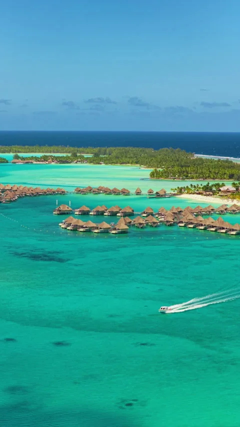 Aerial View of Bora Bora Overwater Bungalows and Speedboat in Turquoise Lagoon. Vídeos de archivo 341989642