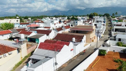 Aerial View of Boy Cycling Through Rural Indian Village Lane with Red Roof 스톡 동영상 340933305